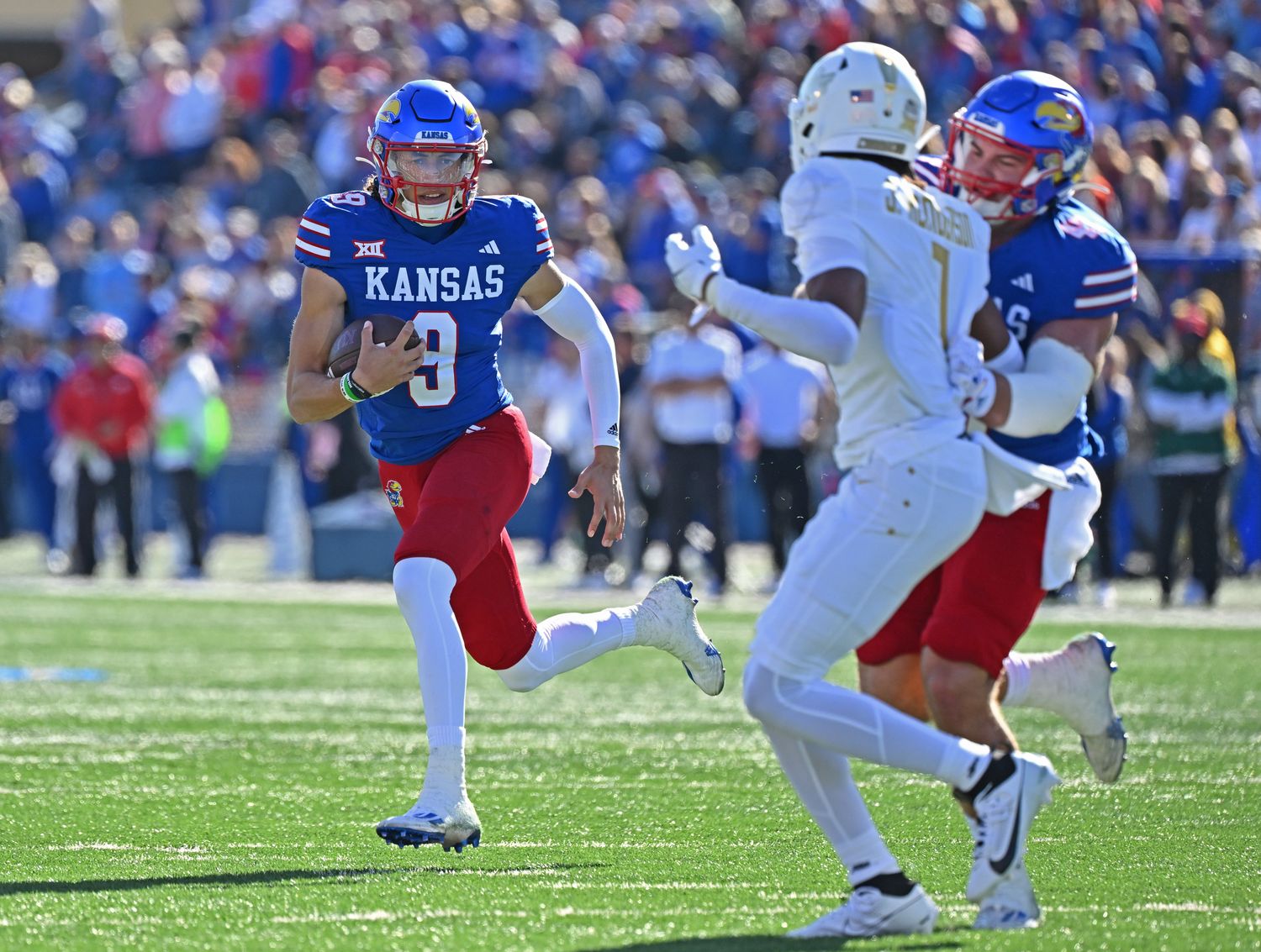 Oct 7, 2023; Lawrence, Kansas, USA; Kansas Jayhawks quarterback Jason Bean (9) runs to the outside against UCF Knights defensive back Ja'Cari Henderson (1) during the first half at David Booth Kansas Memorial Stadium. Mandatory Credit: Peter Aiken-USA TODAY Sports  